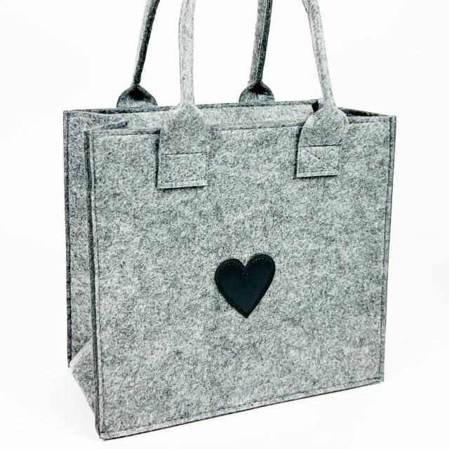 Felt bag in grey with black hearth in the middel.