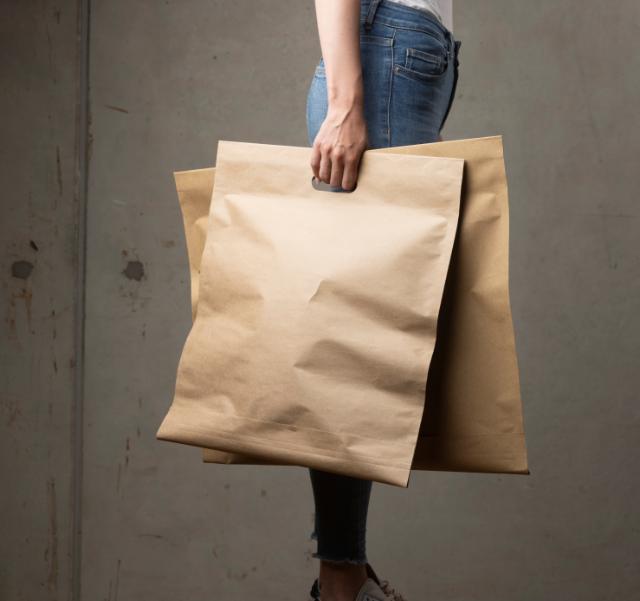 Woman holding brown shipping bags in paper